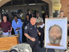 Hampton Police Chief James Turner stands next to a mounted picture of suspect Andre Longmore