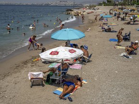 Beach goers are seen at Alimos beach near Athens