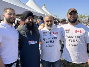 Calgary Forest Lawn MP Jasraj Singh Hallan, second left, is shown standing with Mahmoud Mourra, second right, and two other men. The image was taken from a Facebook page posted by Mourra. Conservative Leader Pierre Poilievre's office is keeping tight-lipped over a front-bench member of Parliament posing for the photo with two people wearing shirts carrying a message opposed to teaching sex and gender in schools.