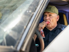 Manuel Solarez eats a popsicle in his car during a heat wave