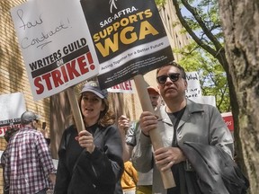 Actors and comedians Tina Fey, center, and Fred Armisen, right, join striking members of the Writers Guild of America on the picket line during a rally outside Silvercup Studios, Tuesday May 9, 2023, in New York.