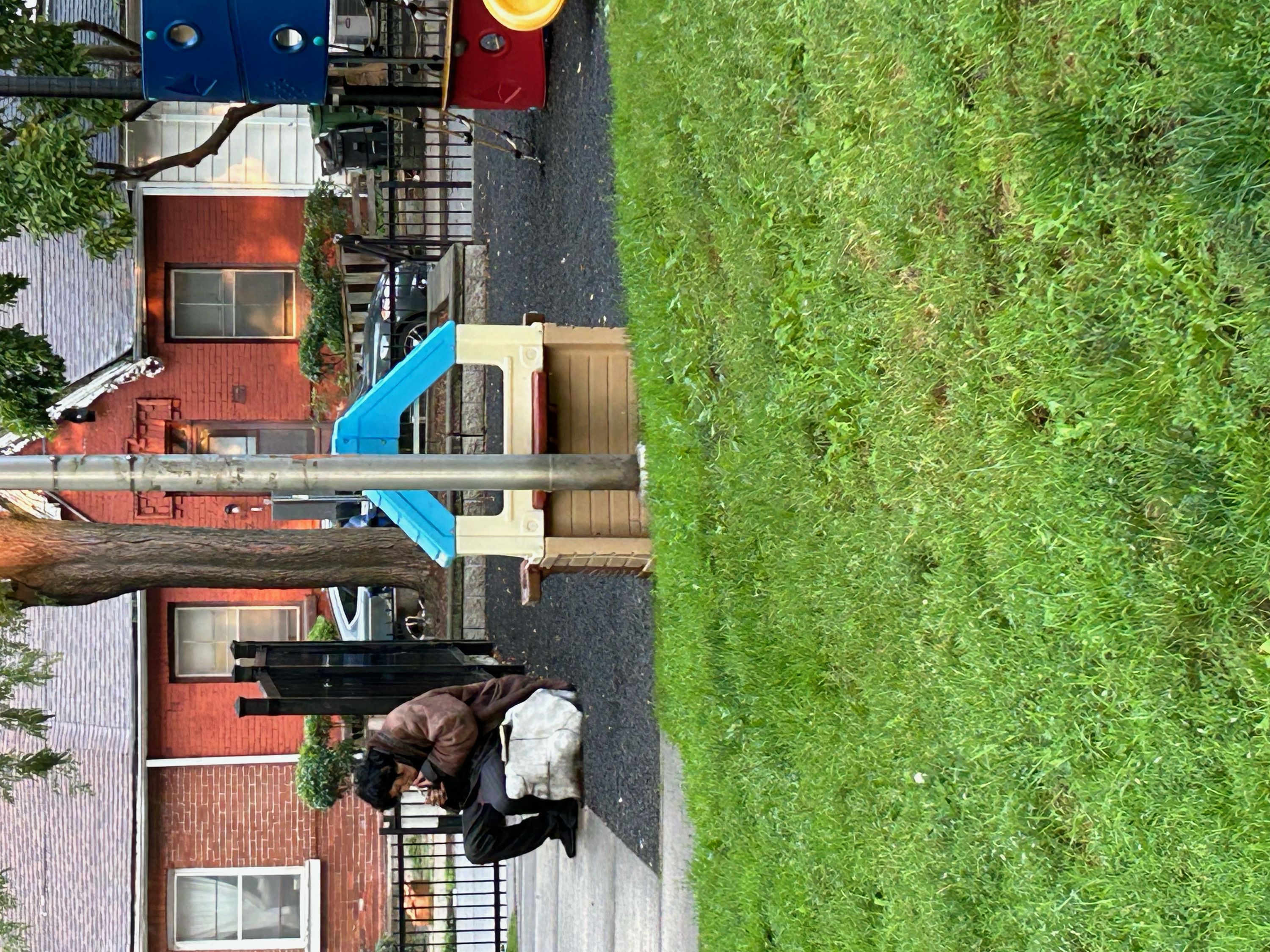 A man smoking a crack pipe in a children's play park in a residential area near one of the city's harm reduction sites.