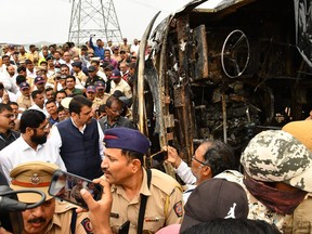 This photo provided by Maharashtra state Chief Minister's Office shows chief Minister Eknath Shinde, front in white, and Deputy chief Minister Devendra Fadnavis visit the site of a bus accident in Buldhana district of Maharashtra state, India, Saturday, July 1, 2023. A tire blowout caused the bus to lose control and crash into a road divider and burst into flames, killing 25 people early Saturday, police told local media. (Maharashtra state Chief Minister's Office via AP)