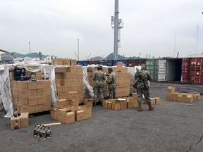 In this photo released by the Mexican Navy, sailors inspect a shipment of bottles labeled mezcal in Manzanillo, Mexico, Saturday, July 22, 2023.
