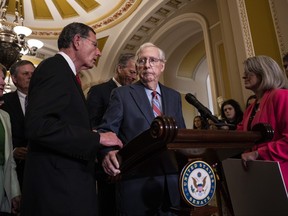 (Left to right) Sen. John Barrasso (R-WY) reaches out to help Senate Minority Leader Mitch McConnell (R-KY) after McConnell froze and stopped talking at the microphones during a news conference after a lunch meeting with Senate Republicans U.S. in Washington, D.C., July 26, 2023.