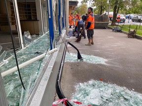 Municipal workers remove a shattered window