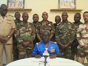 This video frame grab image obtained by AFP from ORTN - Tele Sahel on July 26, 2023 shows Colonel Major Amadou Abdramane (centre), spokesperson for the National Committee for the Salvation of the People (CNSP) speaking during a televised statement.