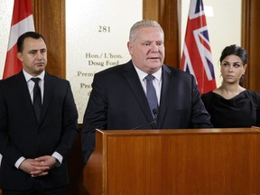 Ontario Premier Doug Ford is flanked by MPP's Michael Parsa, left, and Goldie Ghamari, during a news conference in Toronto, Thursday, Jan. 16, 2020.