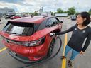 A woman checks the status of the charge for her 2022 Volkswagen ID.4 EV at a charging station at a Scarborough, Ontario Canadian Tire on Wednesday June 14, 2023.
