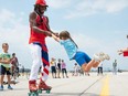 Man on roller skates twirling girl.