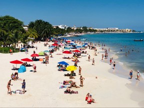 People enjoy a day on the beach in the seaside tourist resort of Playa del Carmen