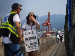 Des travailleurs en grève de l'International Longshore and Warehouse Union Canada manifestent à l'entrée d'un port à Vancouver