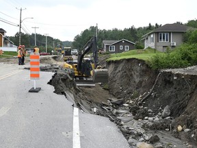 Crews begin repairs to a washed-out section of Highway 170 in Rivière-Éternité, Que., Sunday, July 2, 2023. The search for two people swept away by a landslide in Quebec's Saguenay-Lac-St-Jean region is stretching into a third day.