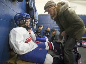 Leanne Domi ties her son Max's skates before a hockey practice, Saturday, Feb. 28, 2004
