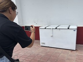 Thai reporter takes a photo of an empty freezer