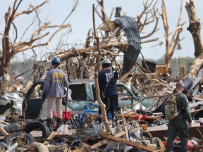 Search and rescue team members continue to look for tornado victims