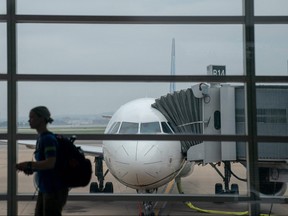 A traveller walks past a United Airlines aircraft, ahead of the July 4th holiday