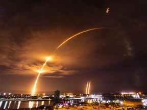 In a time exposure, a SpaceX Falcon Heavy rocket launches from Cape Canaveral, Fla., Friday, July 26, 2023. The rocket carried the Jupiter 3 satellite to orbit for EchoStar.