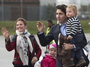 Canadian Prime Minister Justin Trudeau and his wife Sophie Gregoire-Trudeau wave to the media with Hadrien, Ella-Grace as they board a government plane as they leave the United Kingdom Thursday November 26, 2015 in Luton, England. THE CANADIAN PRESS/Adrian Wyld