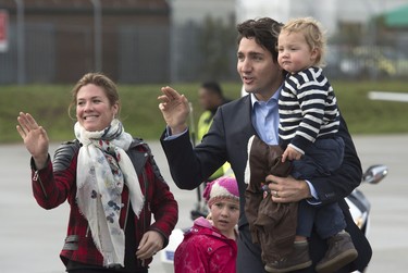 Canadian Prime Minister Justin Trudeau and his wife Sophie Gregoire-Trudeau wave to the media with Hadrien, Ella-Grace as they board a government plane as they leave the United Kingdom Thursday November 26, 2015 in Luton, England. THE CANADIAN PRESS/Adrian Wyld