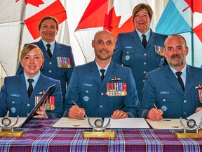 Lt.-Col. Whitney Camm, left, is joined by Col. Leif Dahl, 8 Wing commander, centre, as she takes command of 8 Operations Support Squadron from Lt.-Col. Adam Pentney, right, during a signing ceremony at 8 Wing Trenton on July 6, 2023.