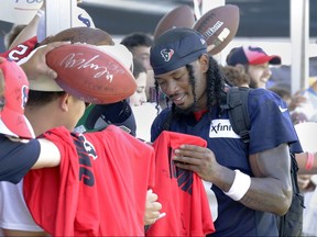 Houston Texans wide receiver John Metchie III gives autographs to fans after the team's training camp.