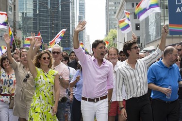 Canada's Prime Minister Justin Trudeau (C), his wife Sophie Grégoire, and Queer Eye star Antoni Porowski, right, march in the Pride Parade in Montreal, August 19, 2018. (Christinne Muschi /Postmedia)