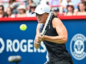Iga Swiatek of Poland hits a return against Karolina Muchova of the Czech Republic during the National Bank Open at Stade IGA on Aug. 10, 2023 in Montreal.
