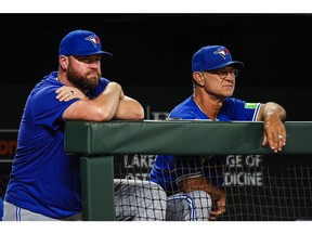 Blue Jays manager John Schneider (left) and bench coach Don Mattingly watch the play against the Baltimore Orioles.