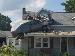 A car is lodged into the second storey of a home.