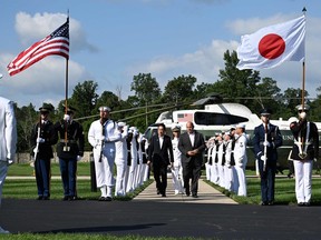 Japanese Prime Minister Fumio Kishida (C L) arrives at Camp David in Maryland on August 18, 2023, to attend a summit with US President Joe Biden and South Korean President Yoon Suk Yeol.