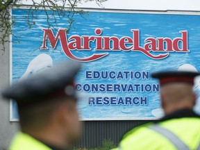 Police officers block protesters from an entrance to Marineland grounds in Niagara Falls, Ont., on Saturday, May 20, 2023. THE CANADIAN PRESS/Alex Lupul