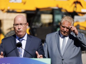 Ontario Premier Doug Ford listens as Minister of Housing Steve Clark speaks during a press conference in Mississauga on Friday, Aug. 11, 2023.