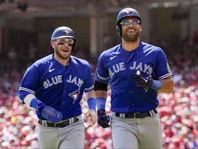 The Toronto Blue Jays' Kevin Kiermaier jogs to the dugout with Danny Jansen.