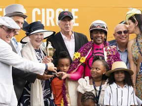 Jockey Patrick Husbands smiles with the trophy.
