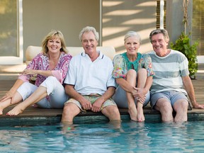 Two mature couples by a swimming pool