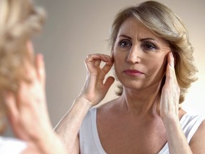 Senior woman touching wrinkled face, thinking about botox injections, age