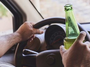 A man drinking beer while driving car