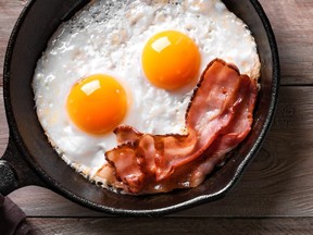 Fried eggs and bacon for breakfast on wooden tabl