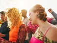 Happy young people dancing at festival