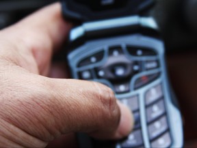A person dials a number on a celluar device