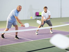 Two men of different ages playing a game of pickleball