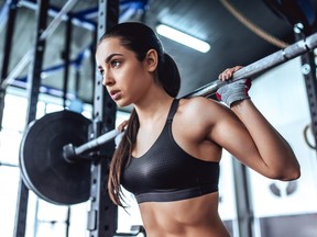 Woman lifting weights in gym.