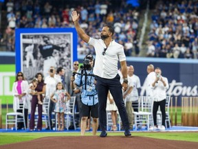 Former Blue Jays player Jose Bautista waves before throwing out the first pitch following a ceremony where his name was unveiled on the "Level of Excellence" before the game against the Cubs at the Rogers Centre in Toronto on Saturday, Aug. 12, 2023.