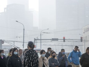 People with masks in Beijing with pollution in the air