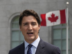 Justin Trudeau with a Canadian flag behind him