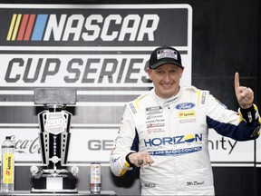 Michael McDowell, driver of the #34 Horizon Hobby Ford, displays his Verizon 200 at the Brickyard winner ring in victory lane after winning the NASCAR Cup Series Verizon 200 at the Brickyard at Indianapolis Motor Speedway on Aug. 13, 2023 in Indianapolis.
