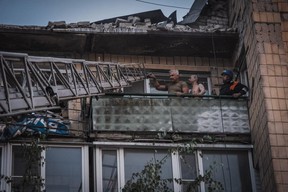 A rescuer evacuating inhabitants from a damaged residential building following Russian missiles strikes in Pokrovsk, Donetsk region