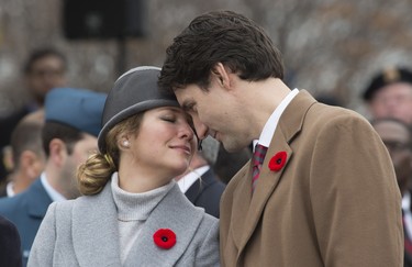 Prime Minister Justin Trudeau and Sophie Gregoire-Trudeau share a moment as they watch Canadian veterans parade past them during Remembrance Day ceremonies in Ottawa Wednesday November 11, 2015. THE CANADIAN PRESS/Adrian Wyld