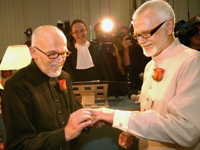 Roger Thibault (left) places a wedding band on Theo Wouters during their wedding at the Montreal Courthouse on Thursday July 18, 2002.